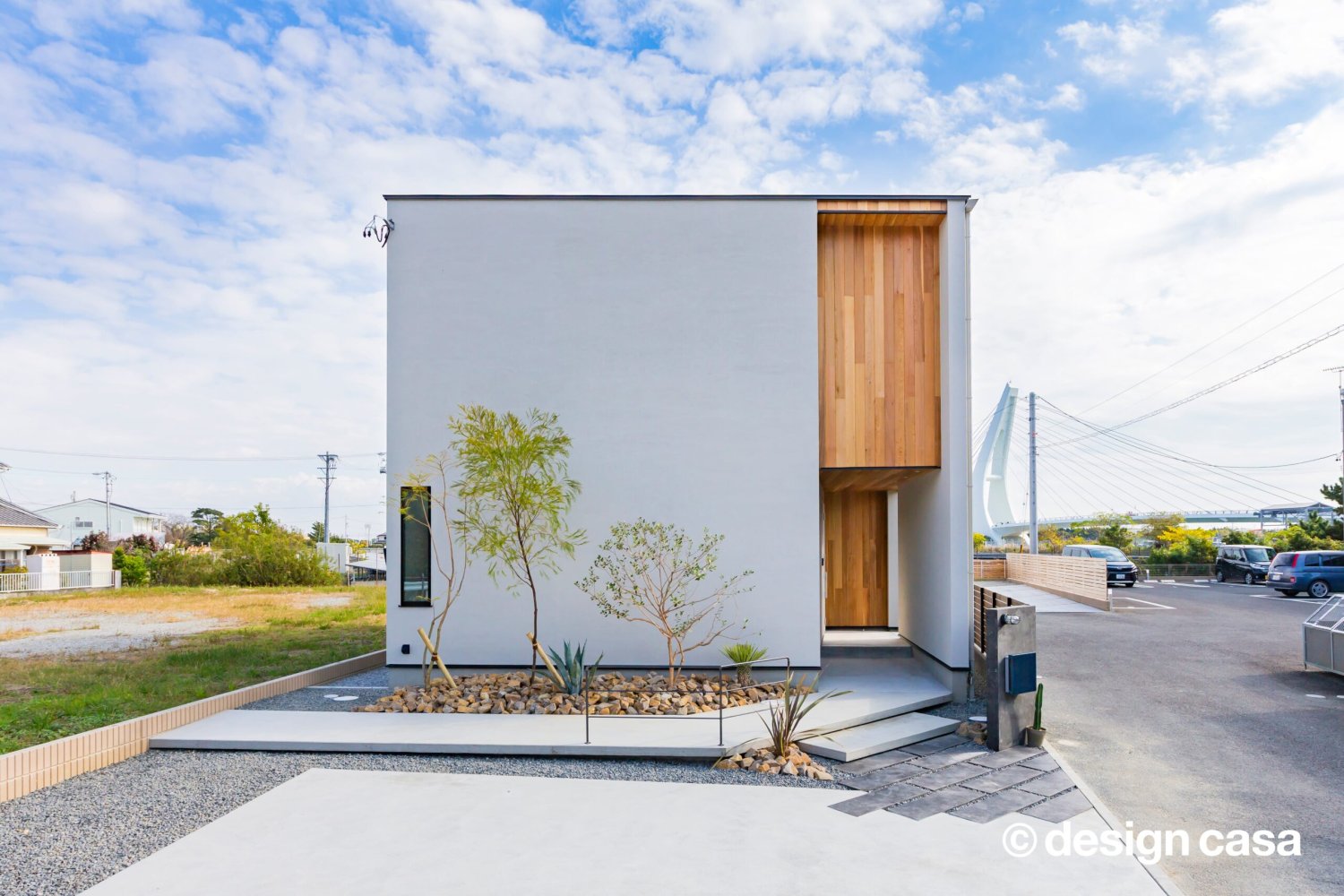 白い外壁と木製玄関の住宅